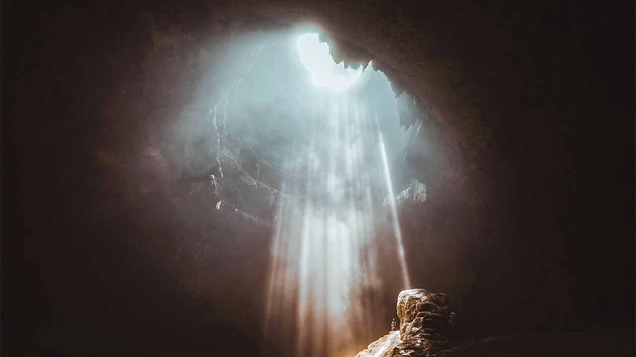 Licht strahlt von oben in eine Höhle hinein